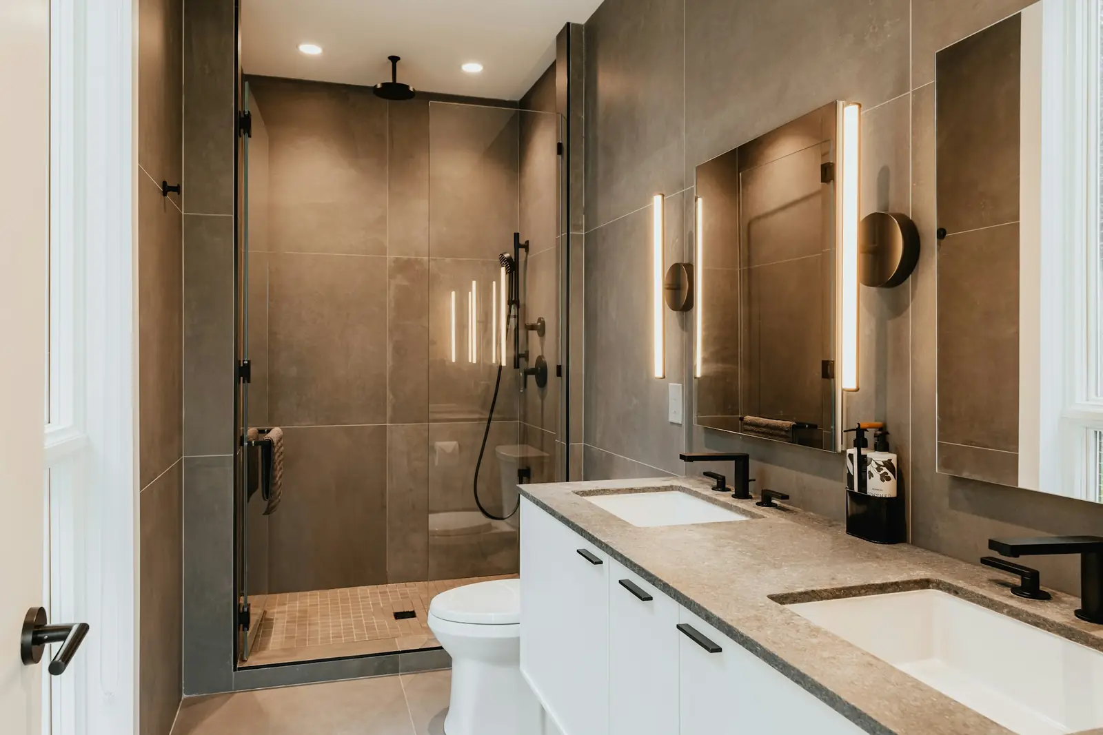 Bathroom with a walk-in shower, twin basins and a toilet